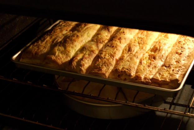 Backbleche mit Lebensmitteln auf Grills, mit schwarzen Seiten links und rechts.