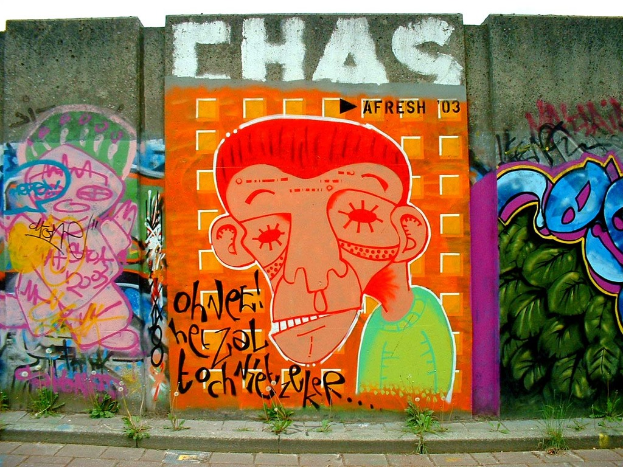 Gemälde an Wänden mit Sträuchern im Vordergrund.