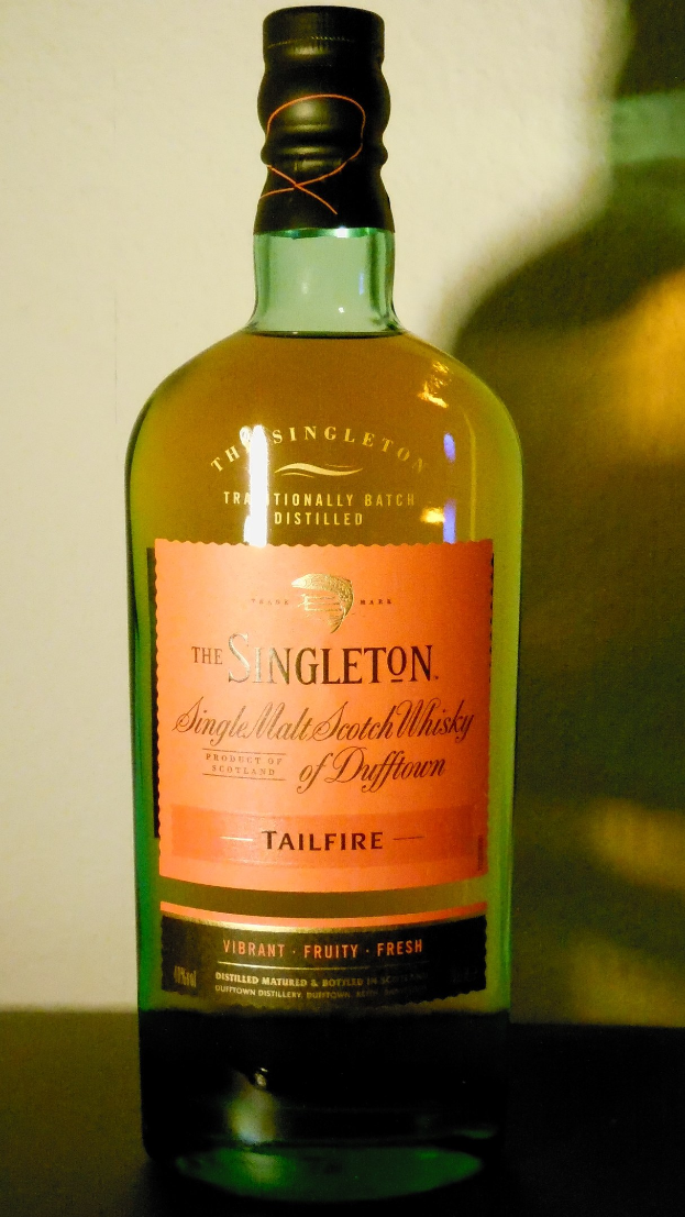Tiefe bernsteinfarbene Flasche Singleton of Dufftown Tailfire Single Malt Scotch Whisky mit einem schwarzen Etikett, das ein Löwen- und ein Schlosswappen zeigt.