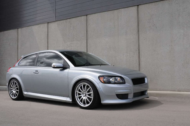 Ein silberfarbener Wagen vor einer Wand geparkt.