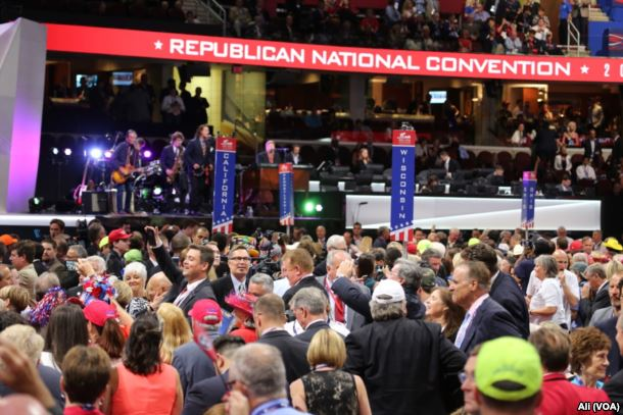 Eine große Menschenmenge auf der Republican National Convention steht vor einer Bühne mit Bannern, Stufen, Stühlen, Musikinstrumenten und Lichtern.