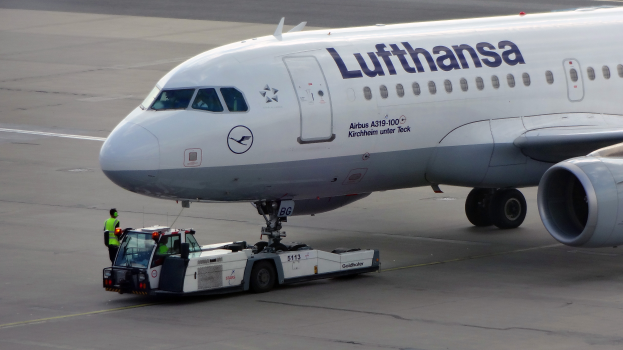 Ein Lufthansa Airbus A319-100 Flugzeug auf der Startbahn am Frankfurt Airport, mit einem Fahrzeug und einer Person in der Nähe, bereit zum Start.