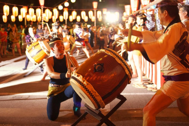 Männer bei einem Festival mit Lichtern über ihnen.