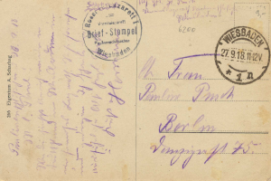 Eine alte Postkarte mit einem violetten "Wiesbaden, Deutschland - 1. Weltkrieg II"-Stempel und handgeschriebener Text.