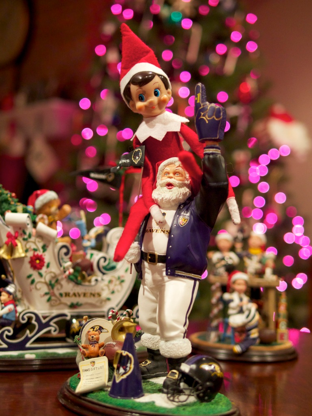 Spielfiguren im Vordergrund mit einem beleuchteten Weihnachtsbaum im Hintergrund.