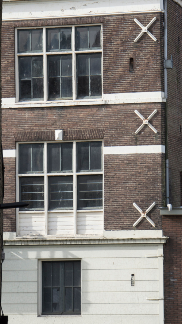 Ein Gebäude mit mehreren Fenstern und sichtbaren Rohren an seiner Außenseite.