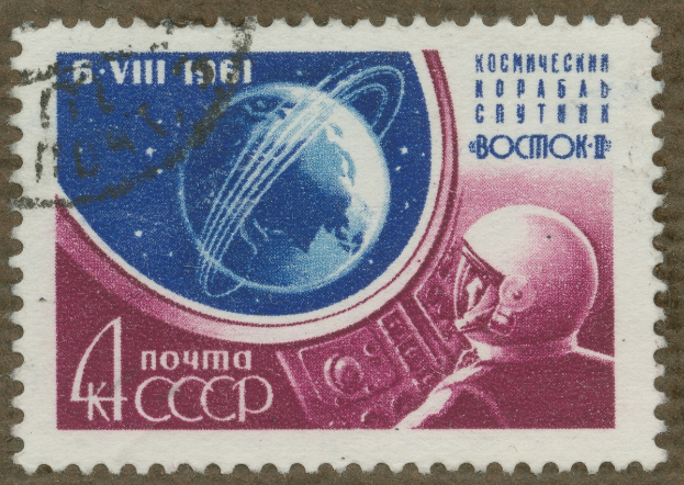 Eine Briefmarke mit einem Mann im Weltraumanzug mit entschlossener Miene, umgeben von der Schrift 'Marke' in fetter, weißer Schrift.