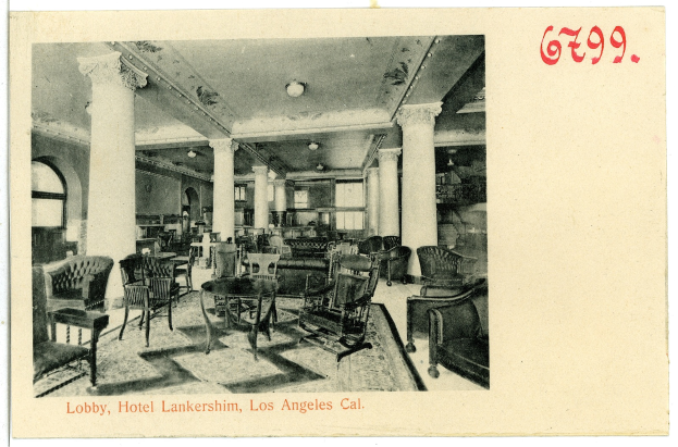 Ein Schwarz-Weiß-Foto einer Hotellobby in Los Angeles, das Stühle, Tische, Säulen, Deckenlampen und Fenster auf der linken Seite zeigt, mit Text am unteren Rand des Bildes.