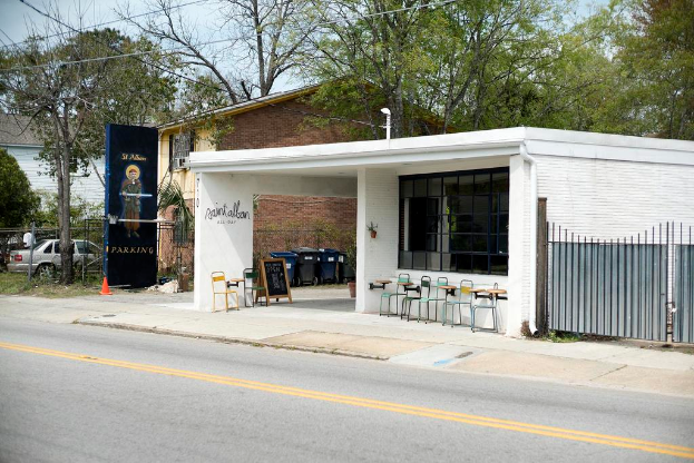 Ein Restaurantgebäude neben einer Straße mit Bäumen im Hintergrund.