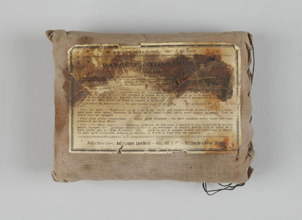 Kleiner Verbandskoffer mit einem informativen Blatt obenauf.