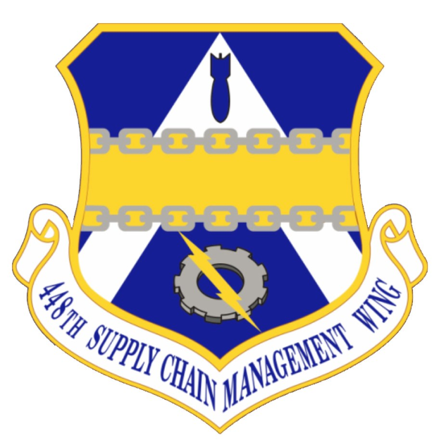 Logo des 48. Versorgungsgeschwader mit einem blauen Schild mit einem weißen Stern, einem weißen Banner mit der Aufschrift "Versorgungsmanagement" in blau und dem Text "48. Versorgungsgeschwader" in fetter schwarzer Schrift.
