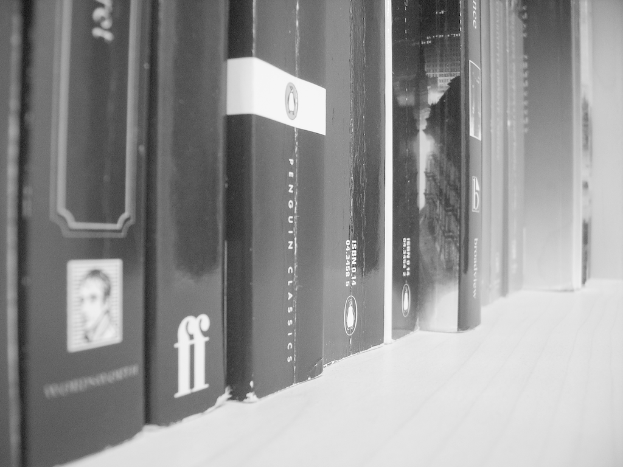 Eine Sammlung von Büchern, die in einer Reihe angeordnet sind, dargestellt in Schwarz-Weiß.