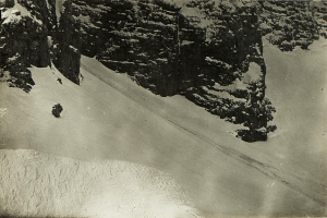Ein Schwarz-Weiß-Foto eines Menschen, der eine schneebedeckte Bergabfahrt öfter, umgeben von schneebedeckten Höllen, mit Text am unteren Rand.