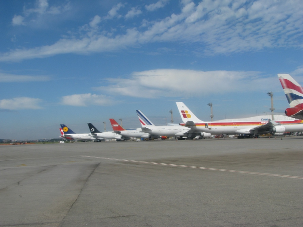 Eine Start- und Landebahn mit wenigen Flugzeugen, Polen, Kabeln und einer bewölkten Himmel.