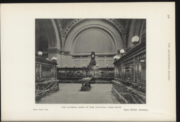 Schwarzes und weißes Foto des Innenraums der National Park Bank in New York City, das Tische, Beleuchtung und eine Wanduhr mit Text am unteren Rand zeigt.