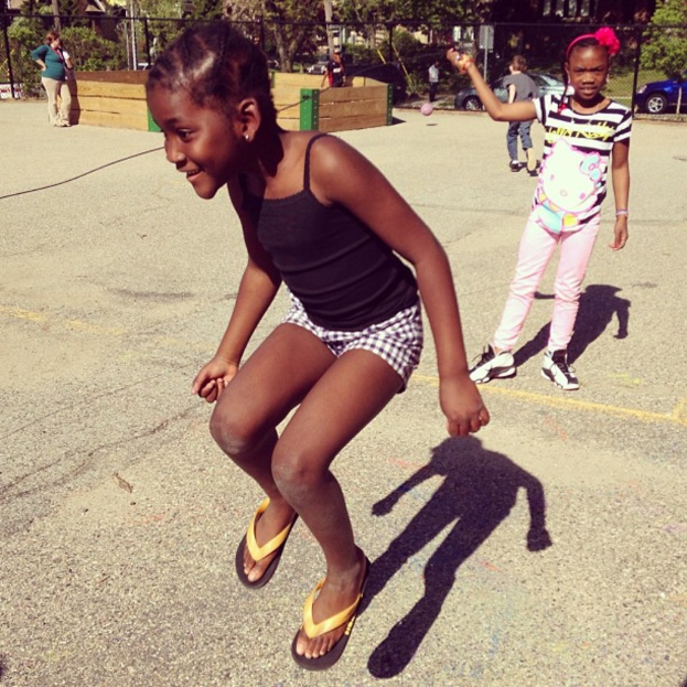 Ein spärlich besiedeltes Gebiet mit einem Zaun, Bäumen und Autos im Hintergrund.