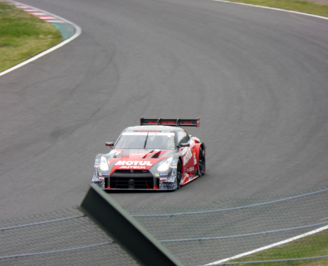 Nissan GT-R Nismo GT3 Rennauto auf der Nürburgring 24 Stunden Strecke mit grünem Gras auf beiden Seiten.