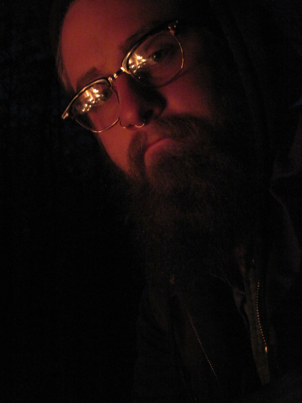 Ein Mann mit einem großen Bart und Brille posiert direkt in die Kamera.